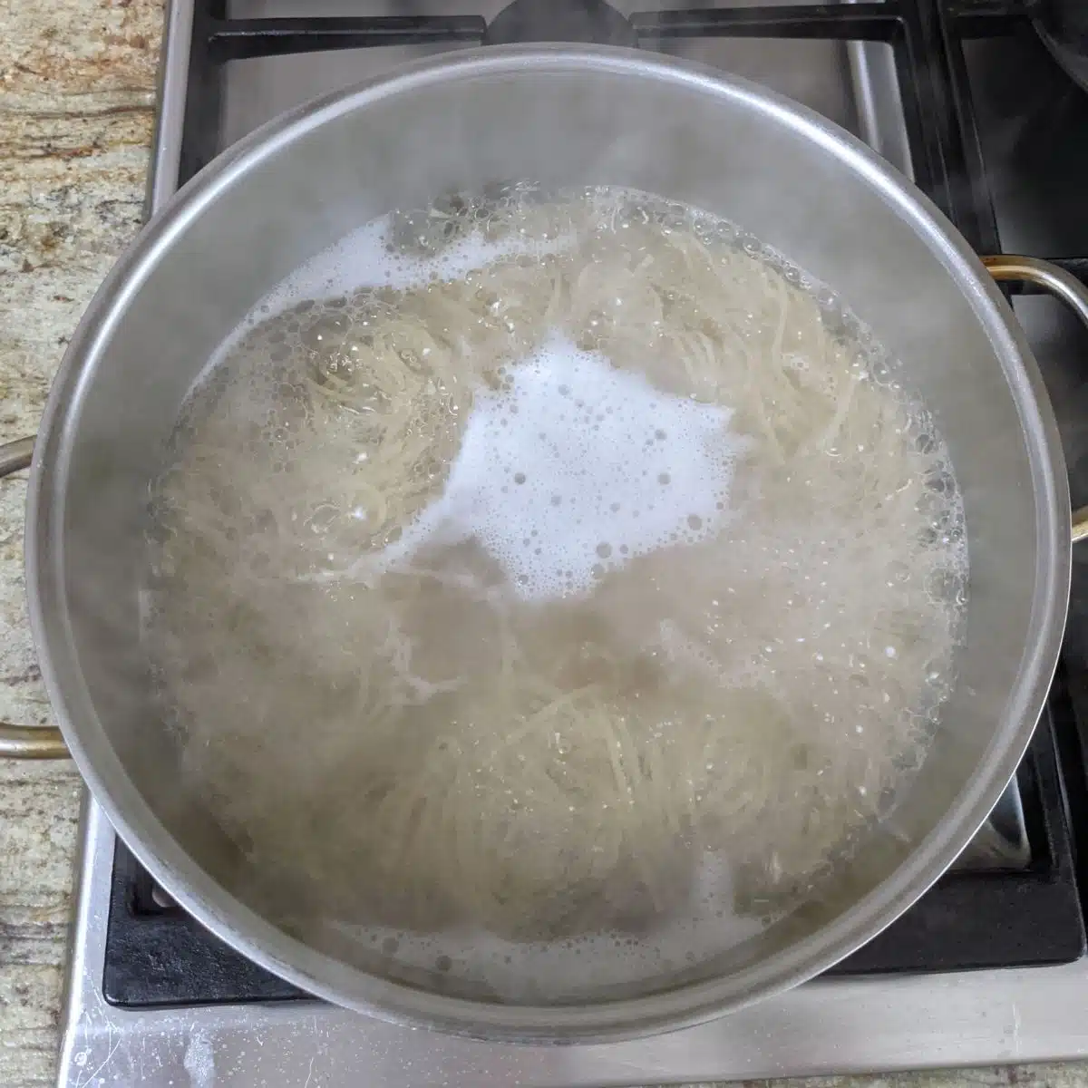 Pot of boiling water cooking pasta. 