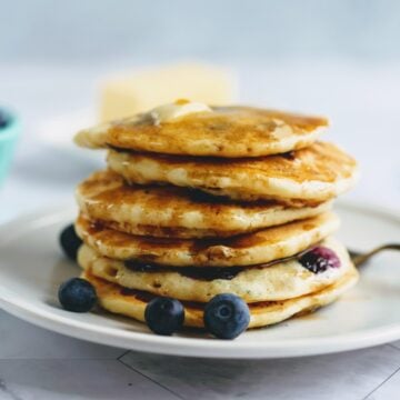 stack of blueberry buttermilk pancakes on plate with fork