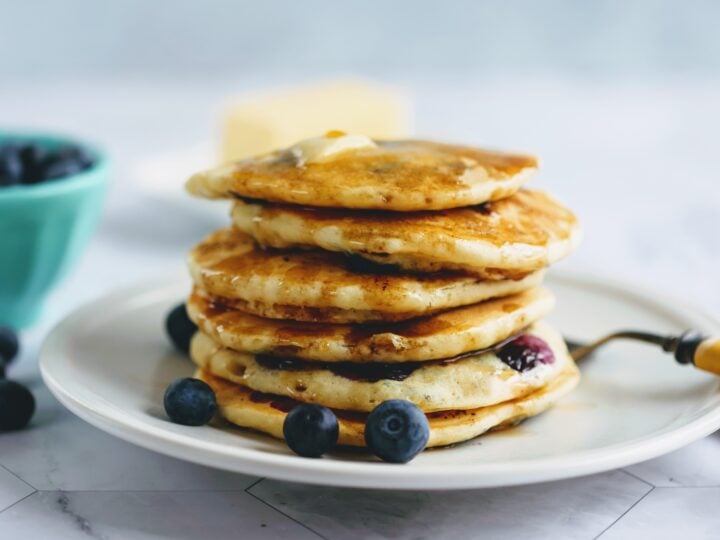 stack of blueberry buttermilk pancakes on plate with fork