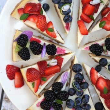 Slices of lemon cheesecake with mixed berries ( blueberry, blackberry and strawberry) topping
