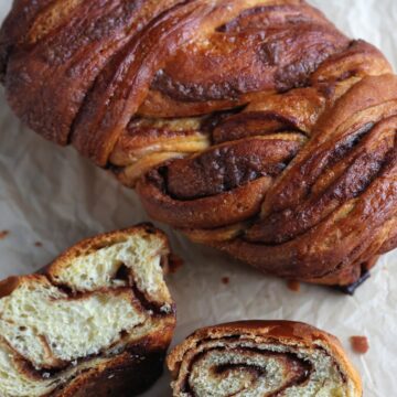 whole loaf cinnamon babka with 2 slices in front of it.