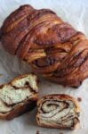 whole loaf cinnamon babka with 2 slices in front of it.