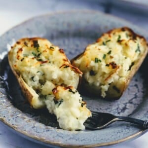 Twice Baked Potato on plate cut in half.
