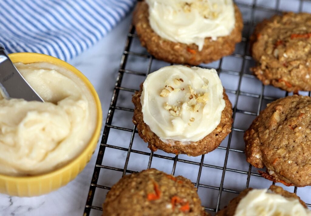 Carrot Cake Cookies on wore rack with bowl of cream cheese icing