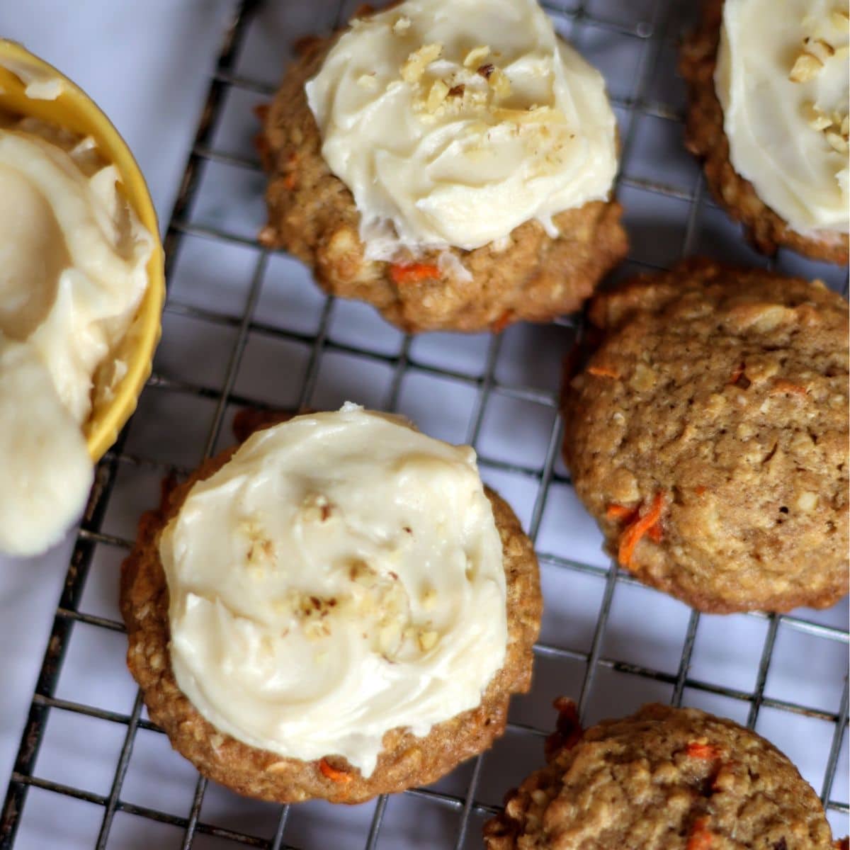 Carrot cake cookies with cream cheese icing on wire rack.