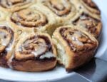 Cinnamon Buns out of pan and one being lifted out