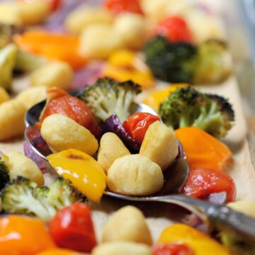 Easy Sheet Pan Gnocchi with Vegetables and Pesto with serving spoon on pan