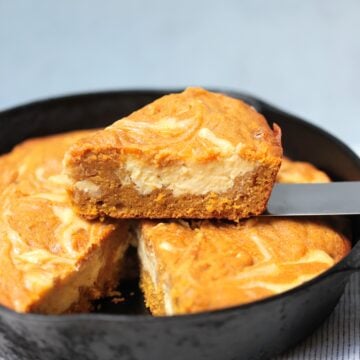 slice of pumpkin cream cheese cake on spatula above skillet