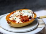 Bolognese-Stuffed Spaghetti Squash on a plate with a forkful removed