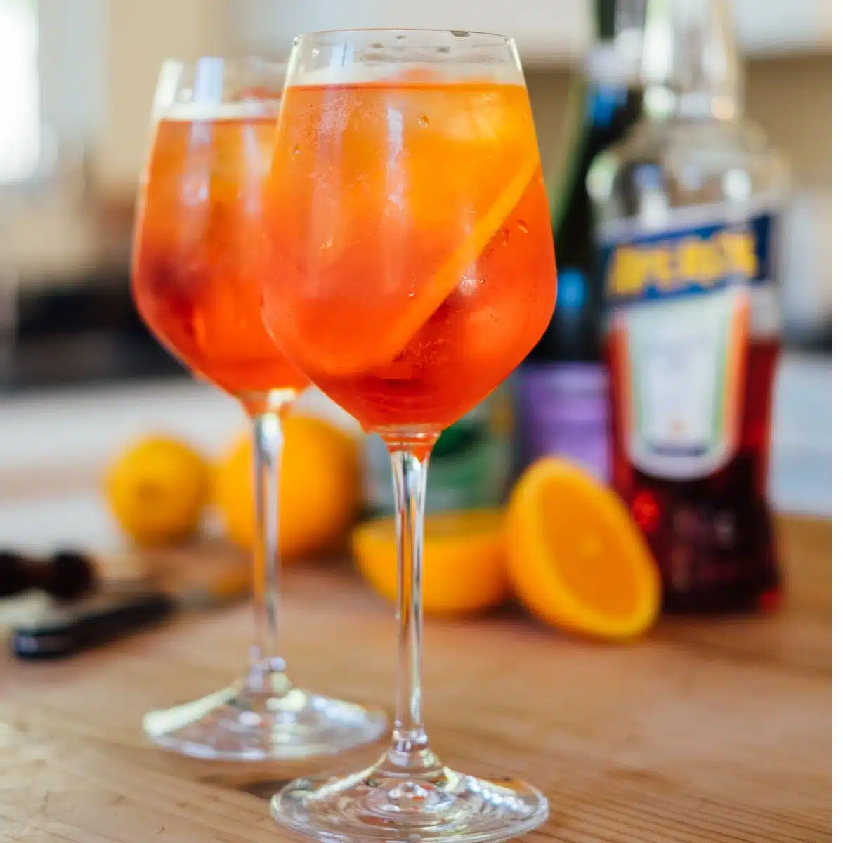 Two stemmed glassed filled with Aperol Spritz.