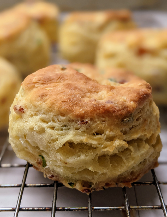 Flaky bacon and chive biscuits on a cooling rack