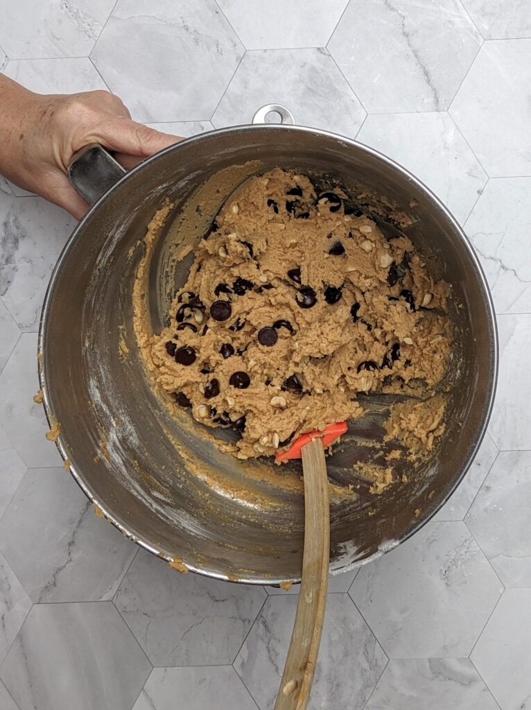 Overhead shot folding in the chocolate chips and peanuts into the cookie dough