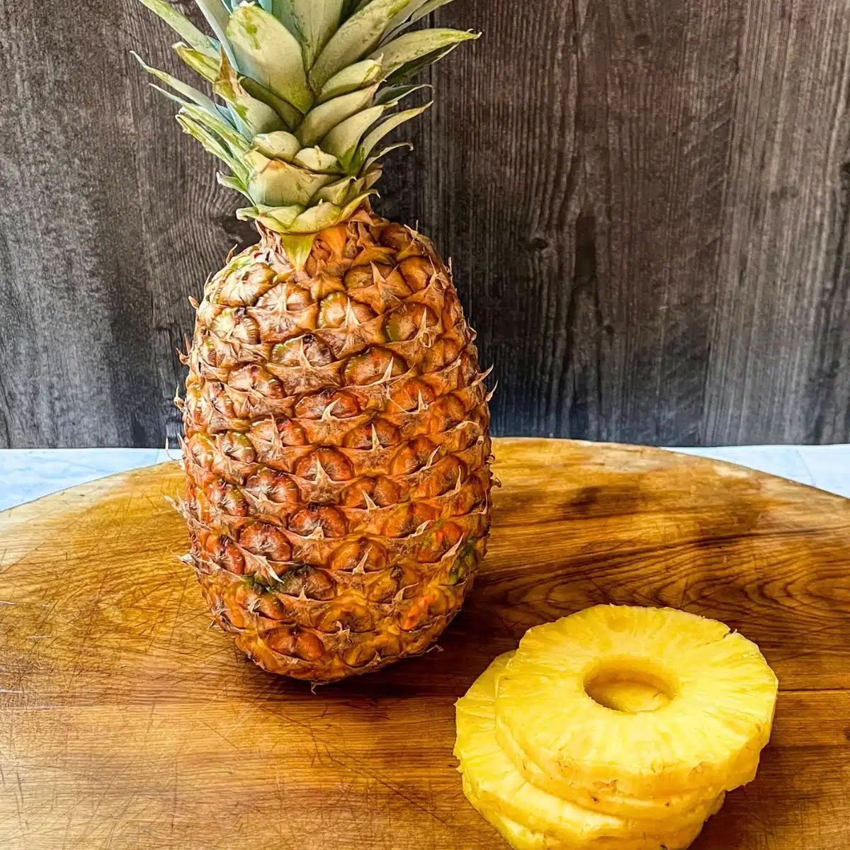 How to cut pineapple. Whole pineapple with slices on board. 