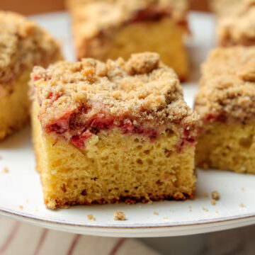 Slice of Strawberry Coffee Cake on a serving platter with pieces in background.