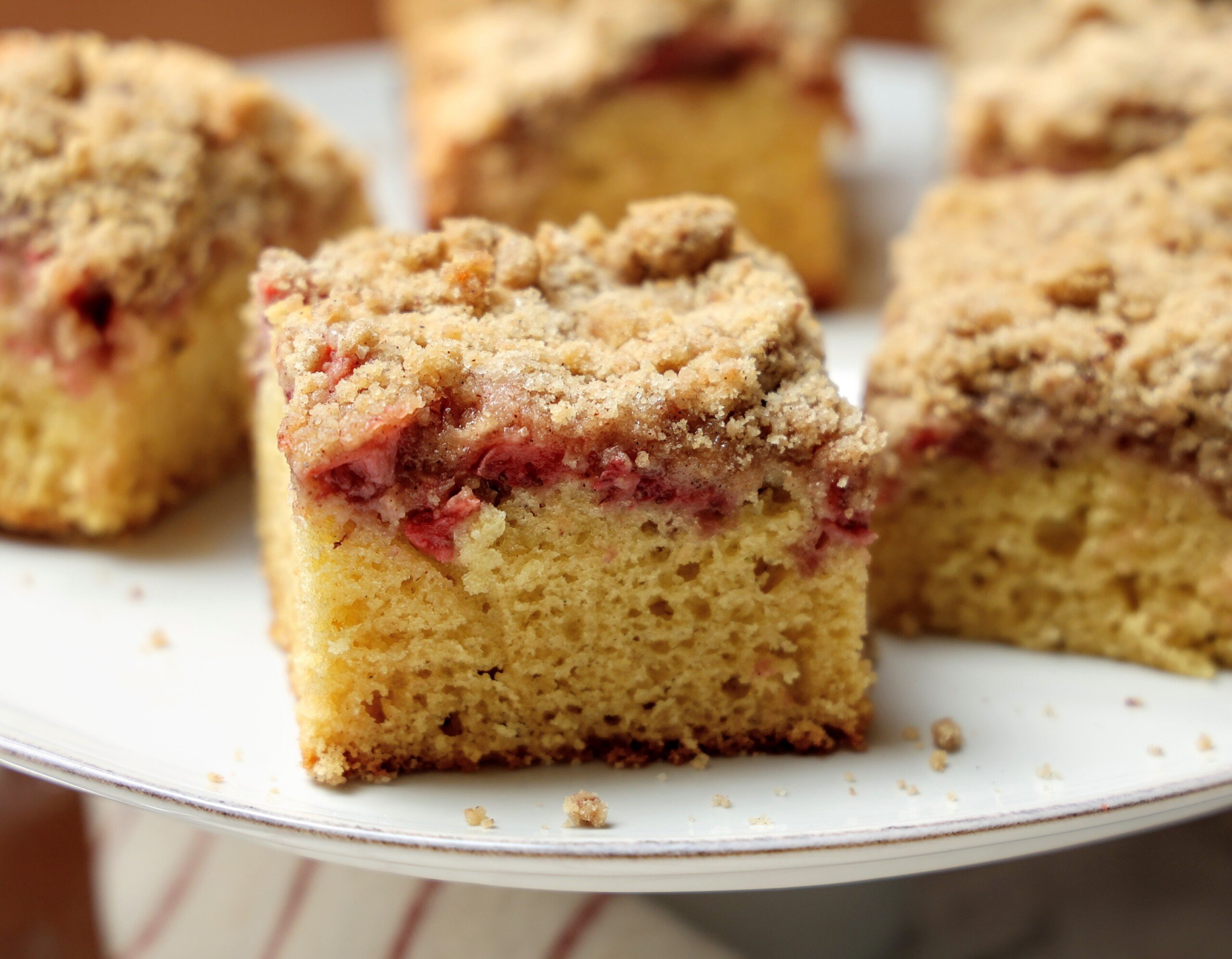 Close up of slice of strawberry coffee cake with crumb topping. 