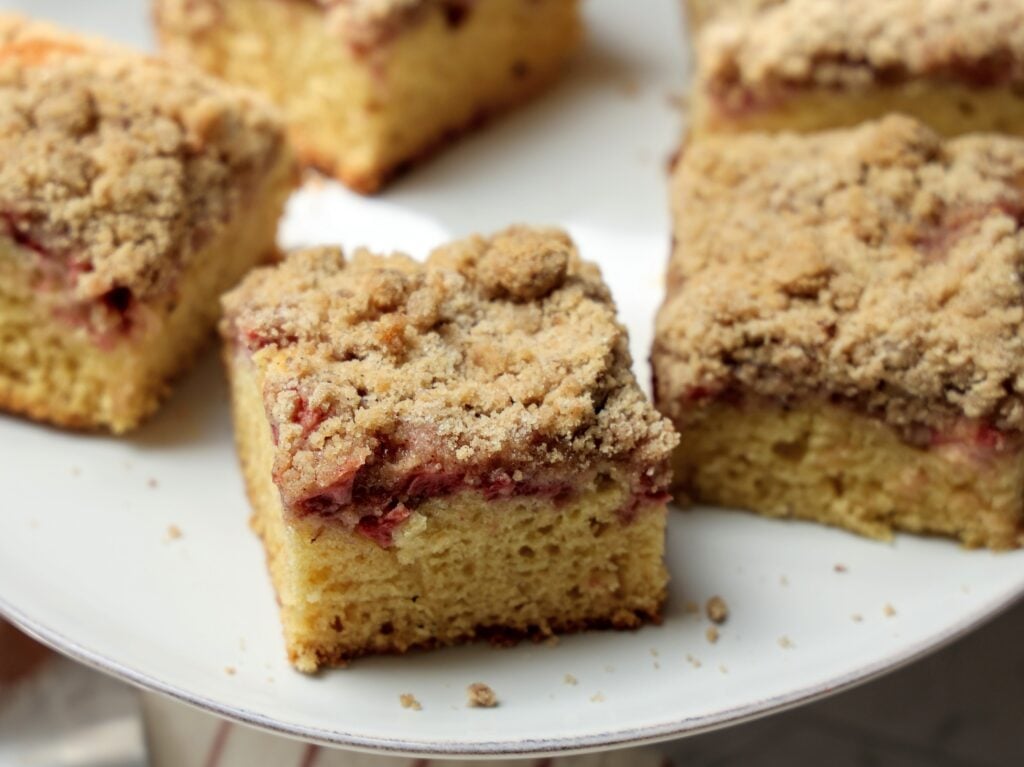 White plate of strawberry crumb cake cut into squares