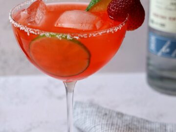 Strawberry margarita in a salt-rimmed stemmed glass.