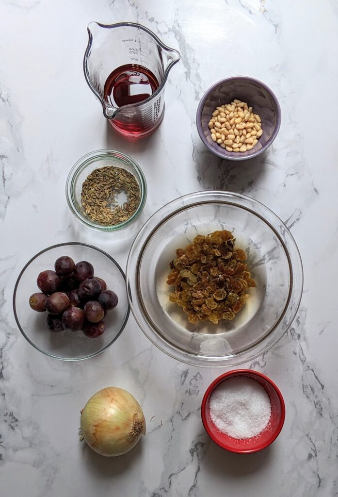 Ingredients shot of golden raisins, pine nuts, onion, red wine vinegar, sugar, fennel seeds, red grapes