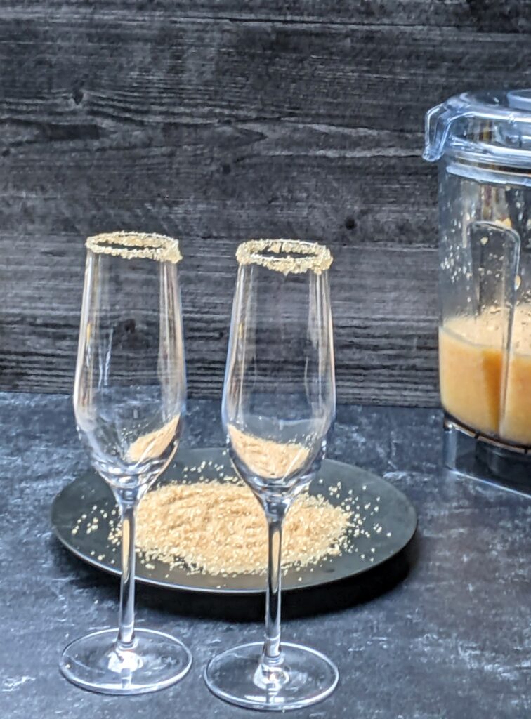 champagne flutes rimmed with raw sugar prior to adding frozen peach bellinis