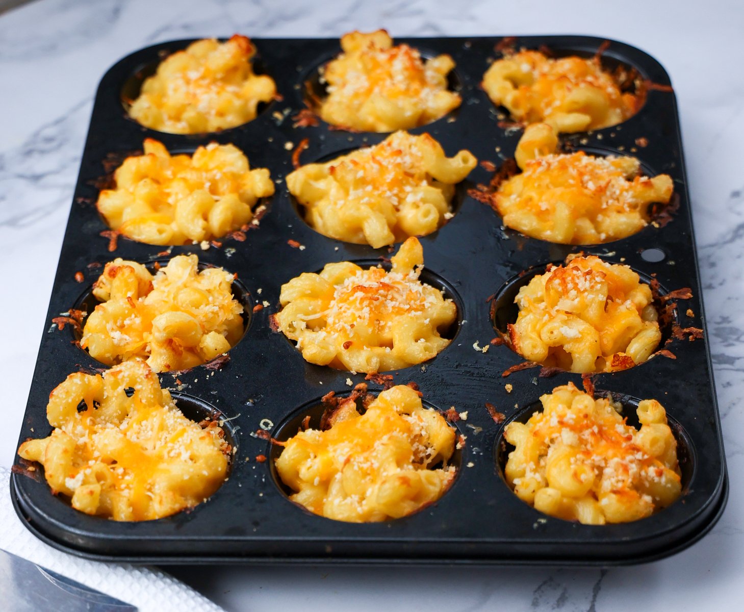 Muffin pan filled with mac and cheese bites.