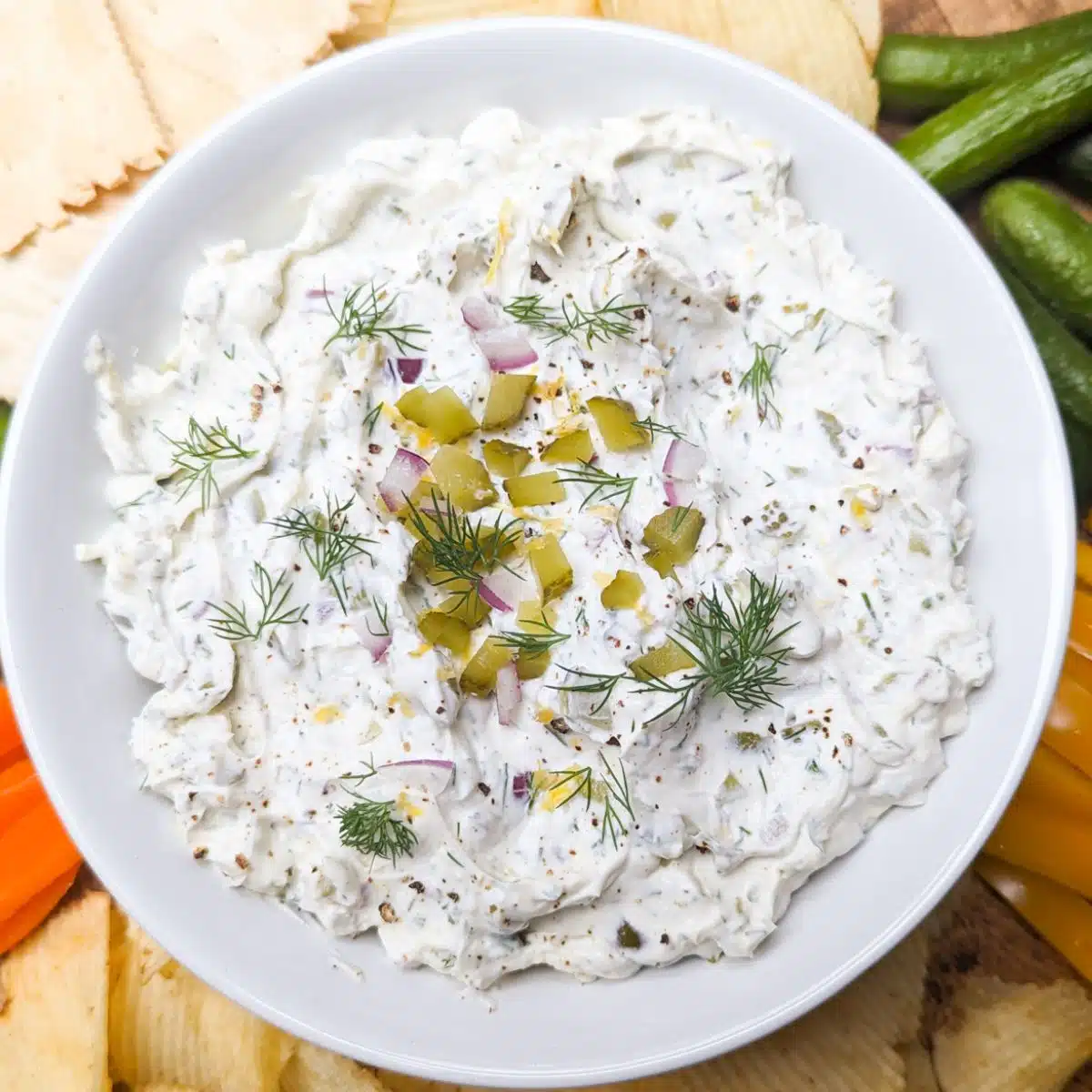 Bowl of pickle dip with fresh vegetables and crackers. 