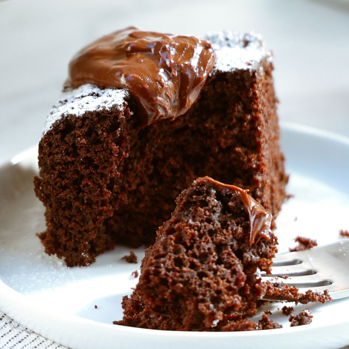 Slice of Everyday Chocolate Cake on plate with bite out.