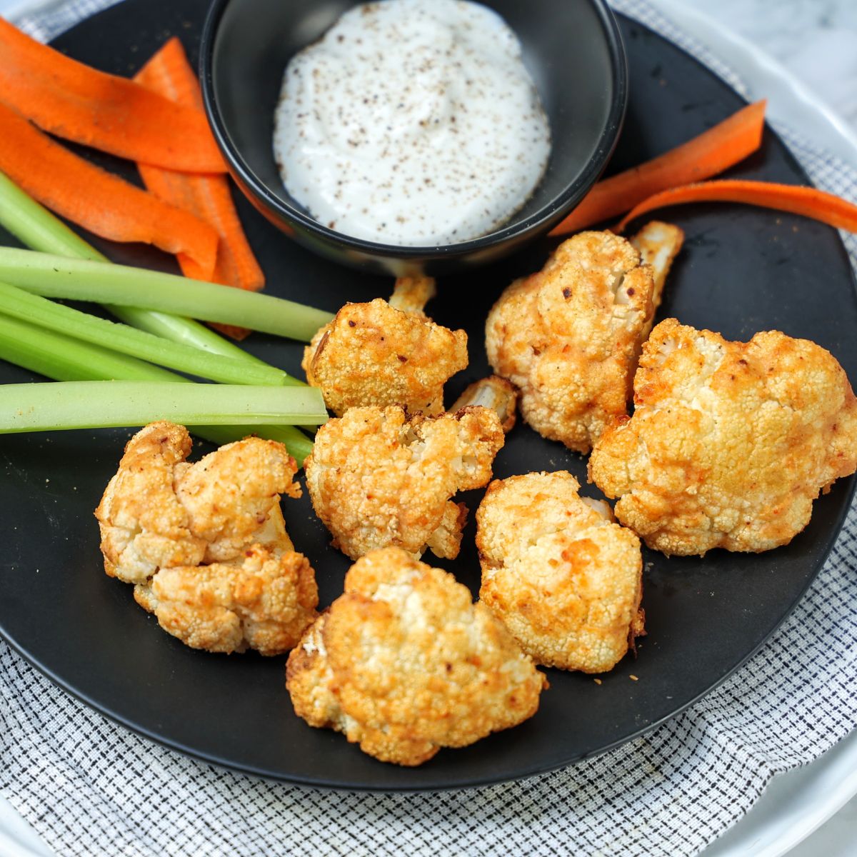 Crispy Cauliflower Bites on a plate with dip.