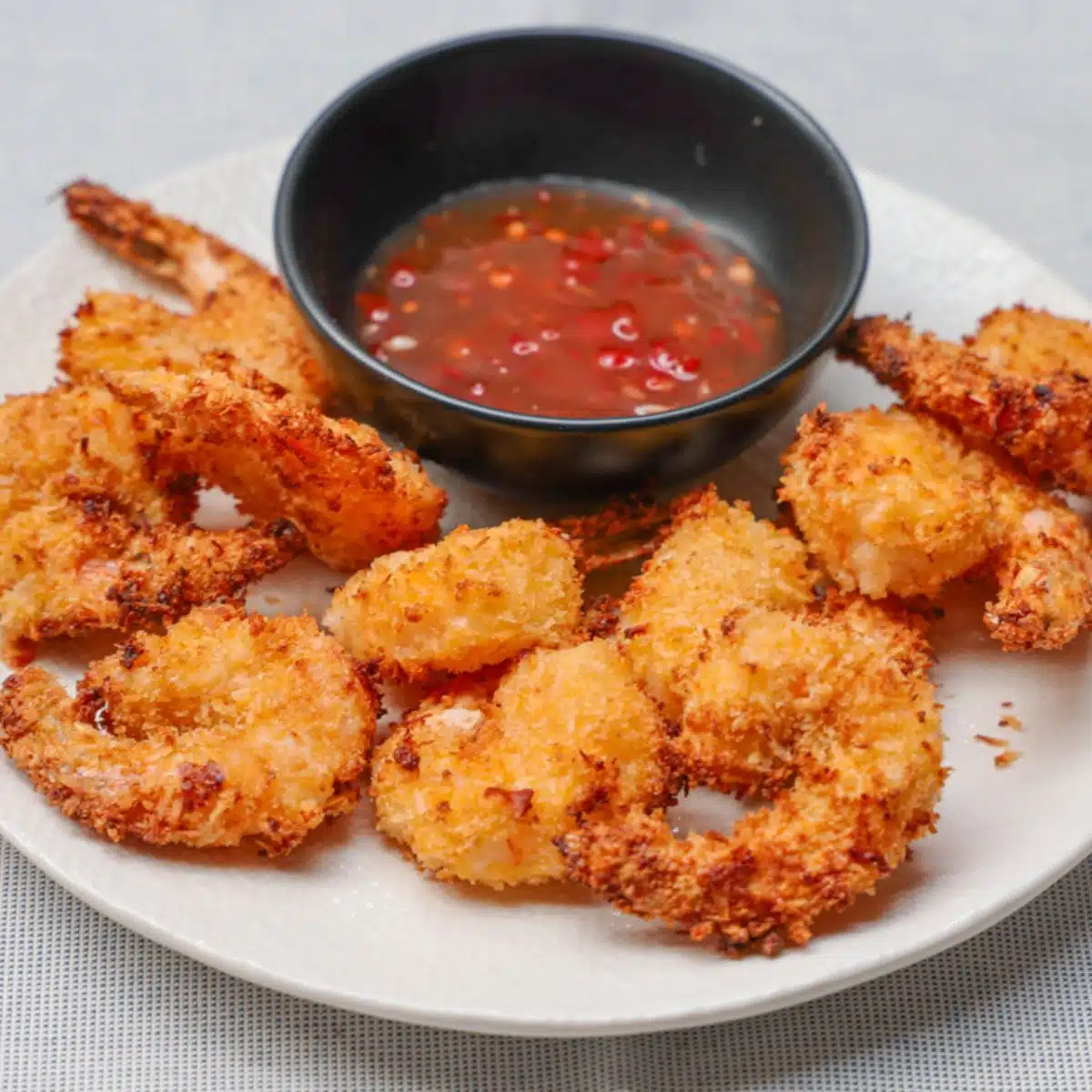 Air Fryer Coconut shrimp on plate with dipping sauce.