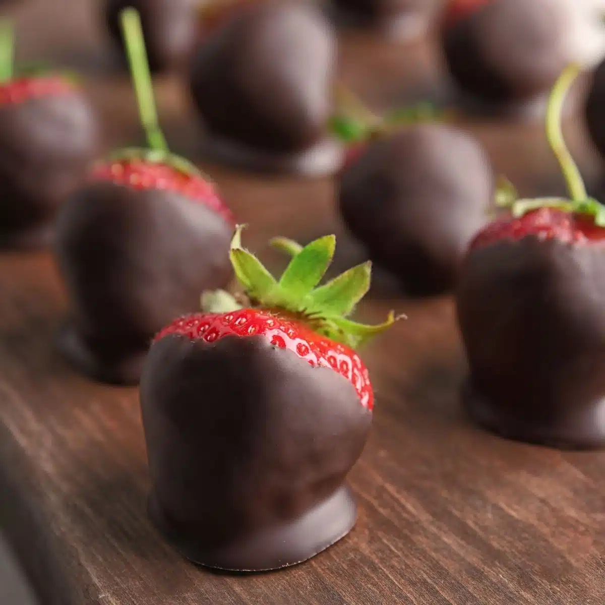 Chocolate dipped strawberries on a cutting board.