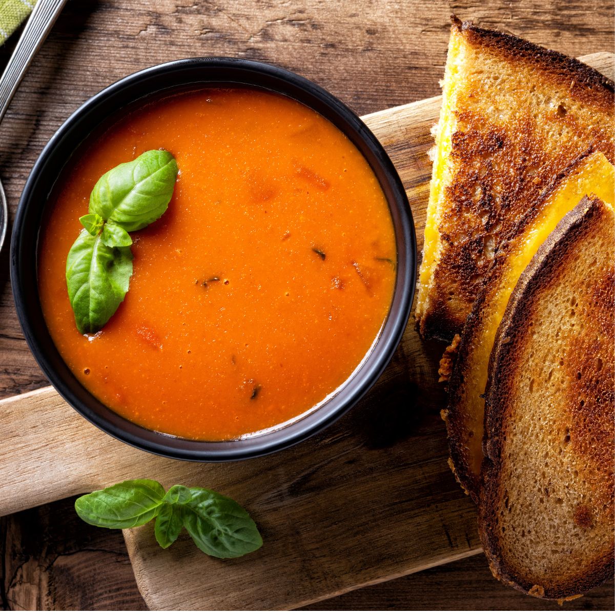 Bowl of tomato soup with grilled cheese.