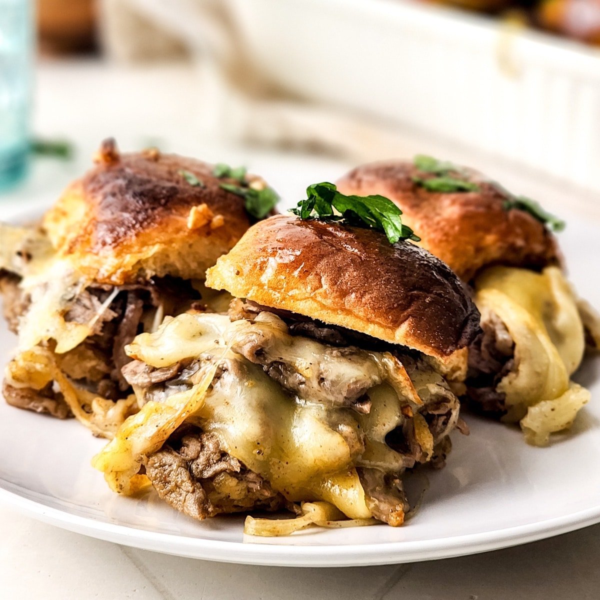 Philly cheesesteak sliders on a plate. 