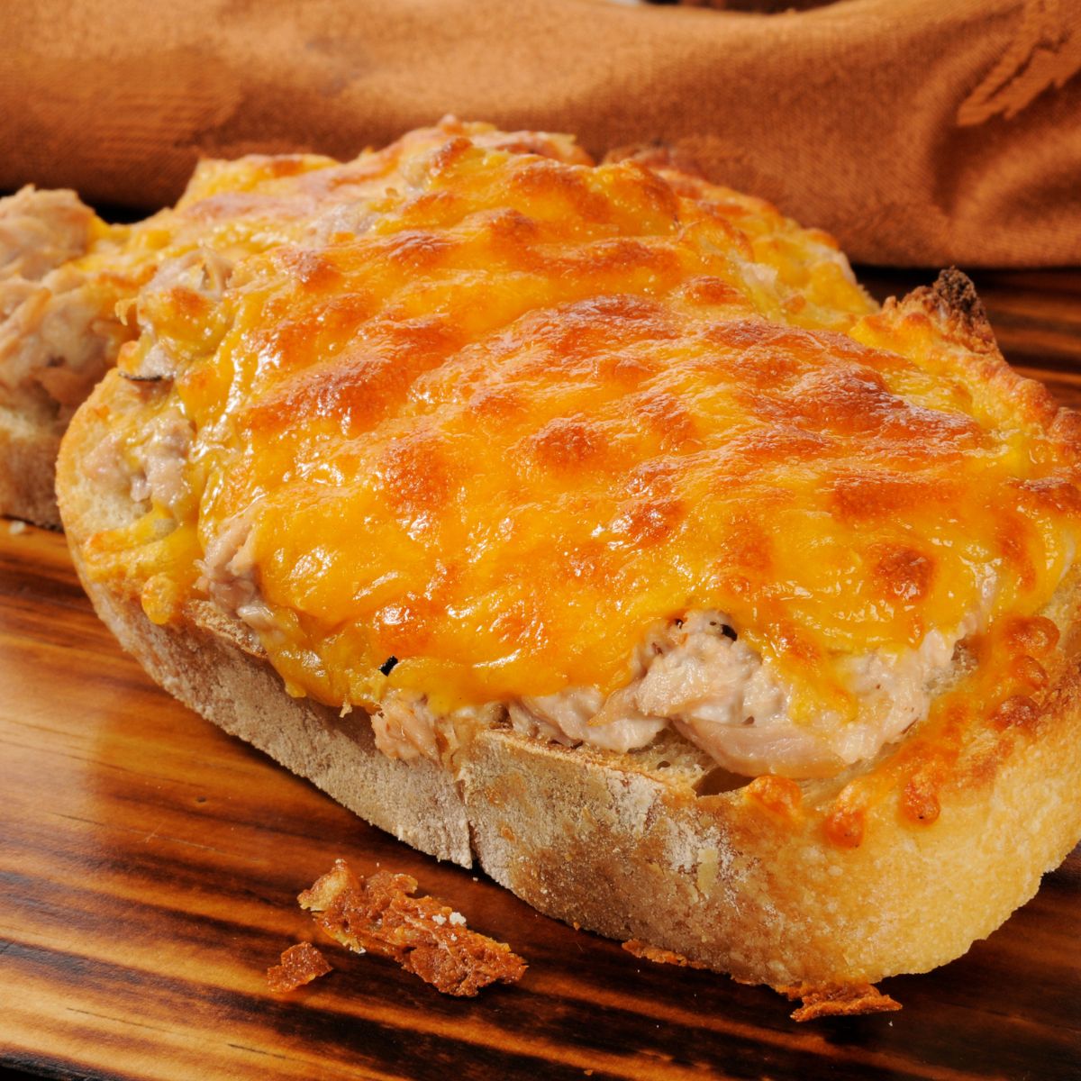 Open-face tuna melt on a plate.