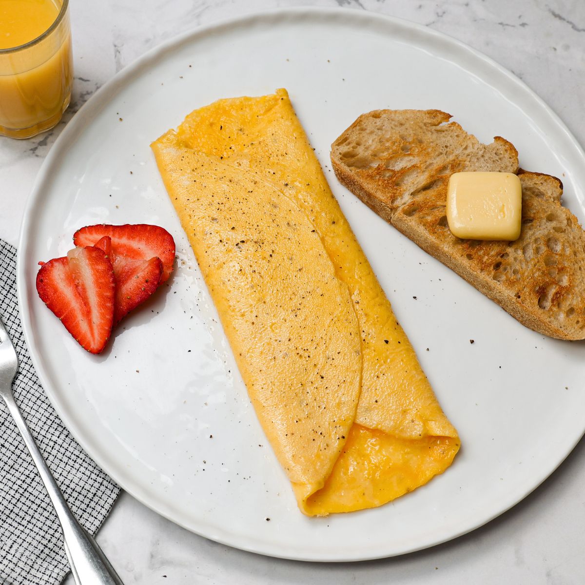 Omelet on plate with toast and berries.