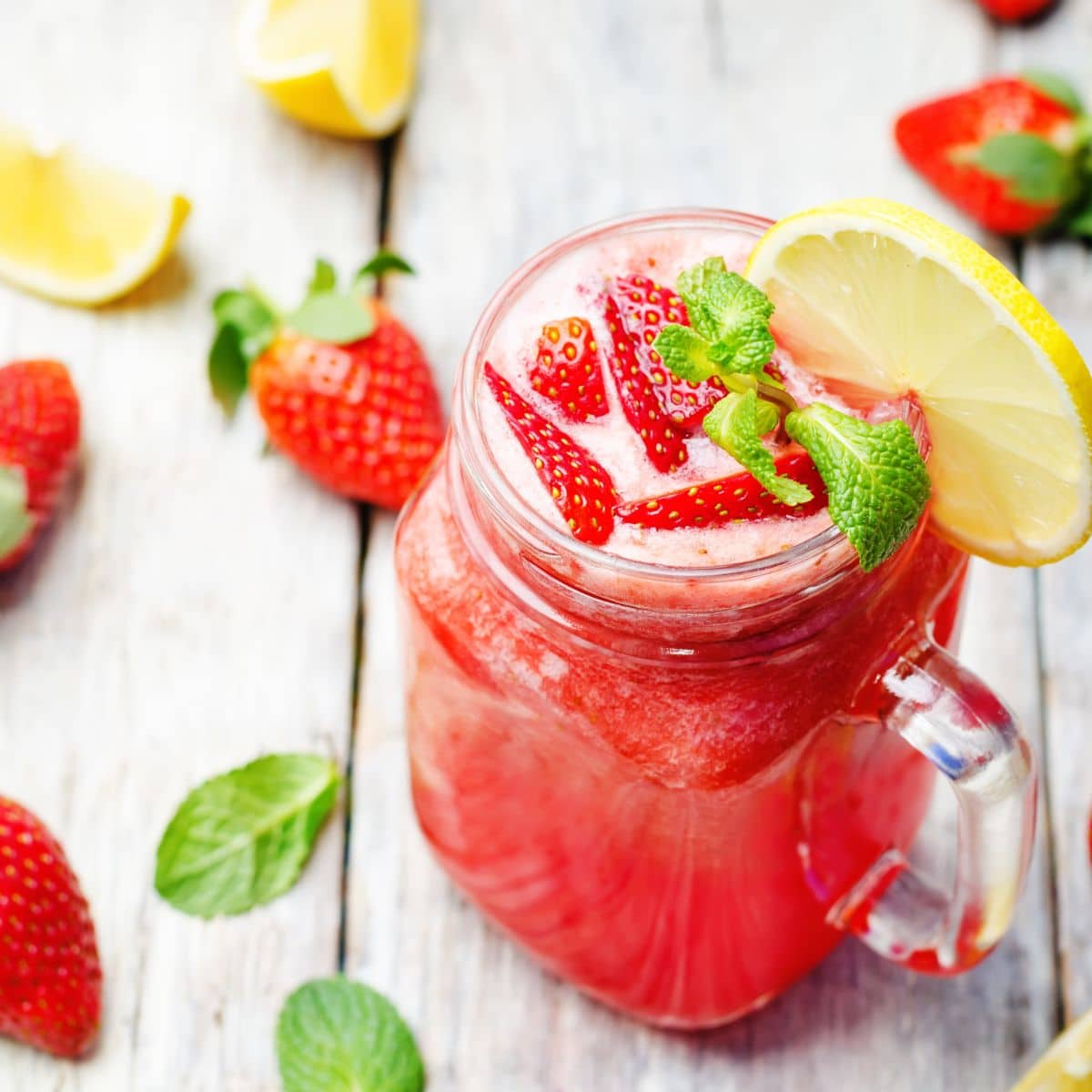 Fresh strawberry lemonade in a mason jar glass. 
