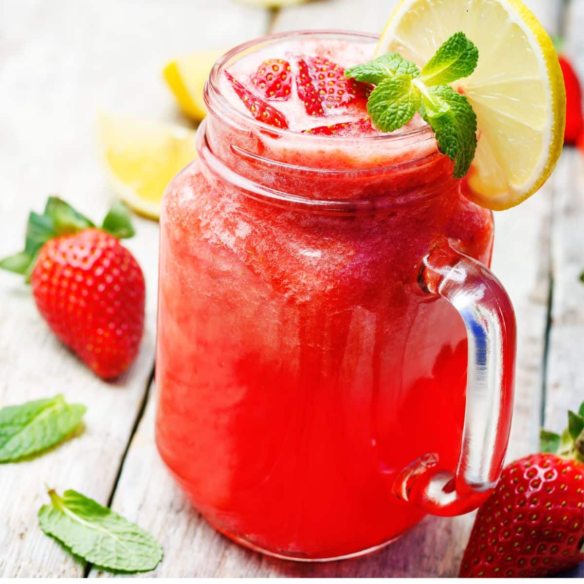 Mason jar glass filled with fresh strawberry lemonade.