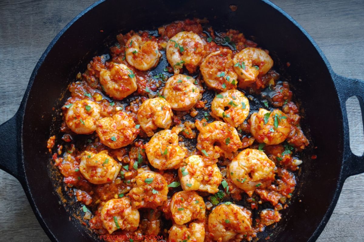 Harissa shrimp in a cast iron skillet.