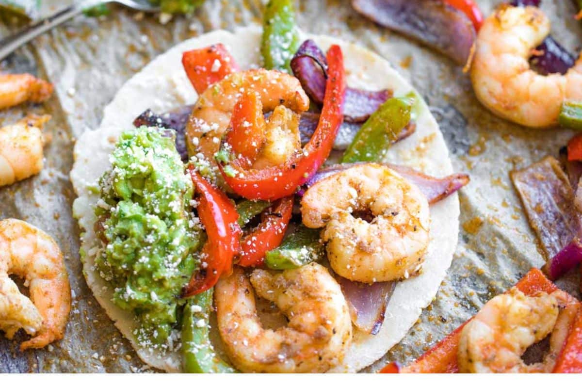 Shrimp fajitas on a baking sheet.